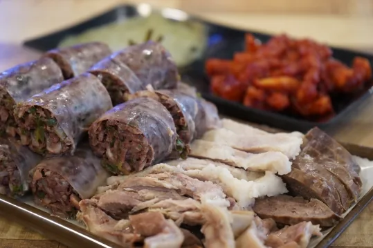 순대와 수육 접시 — 뒤에 붉은 양념 무침